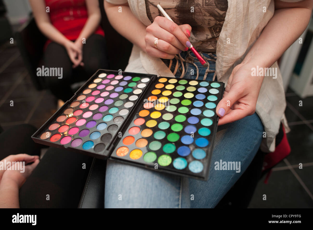 Eine junge Frau, die Wahl der richtigen Farbe bilden für eine Umarbeitung-Session in einem Salon UK Stockfoto