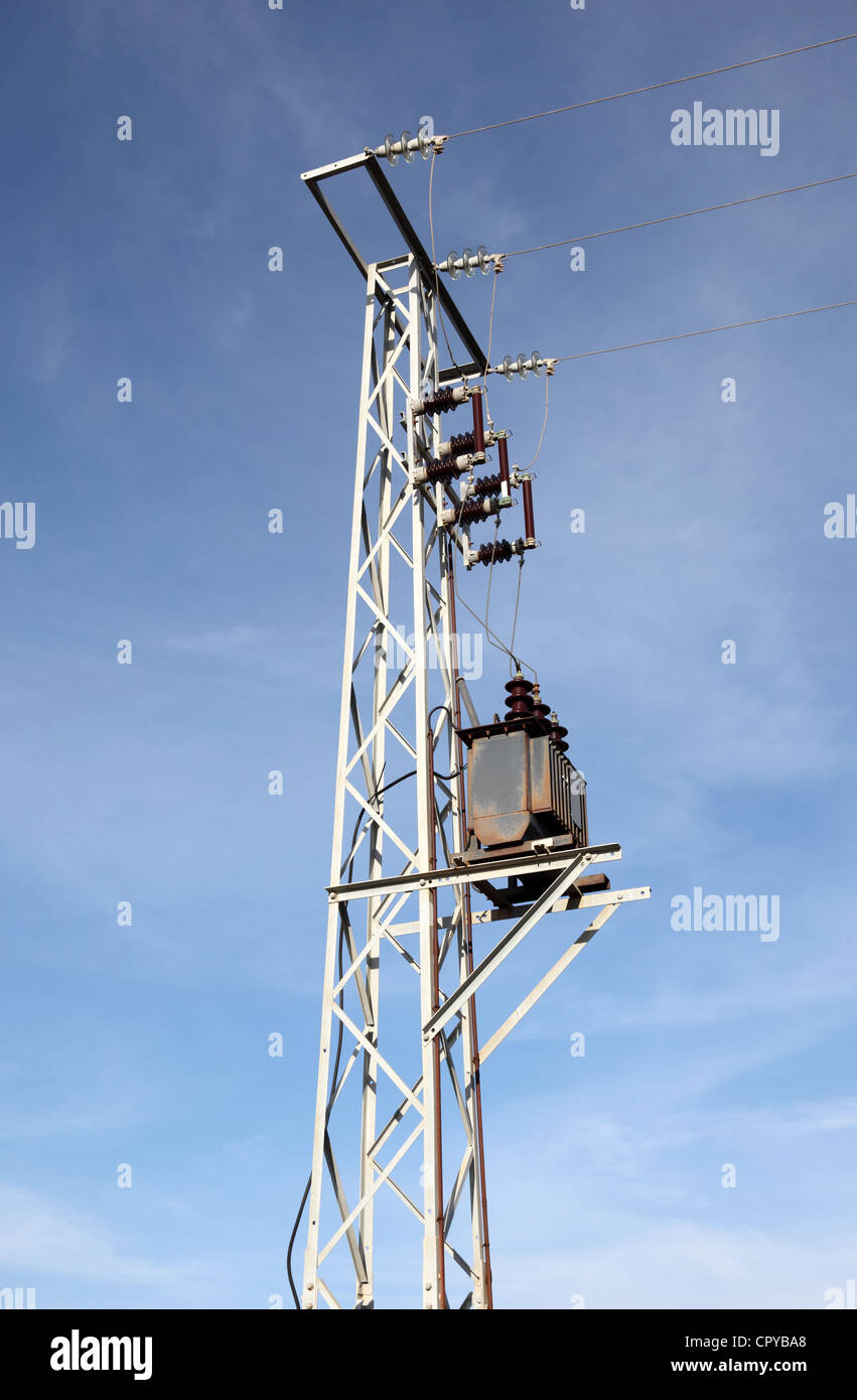 Strommast mit Transformator gegen blauen Himmel Stockfoto