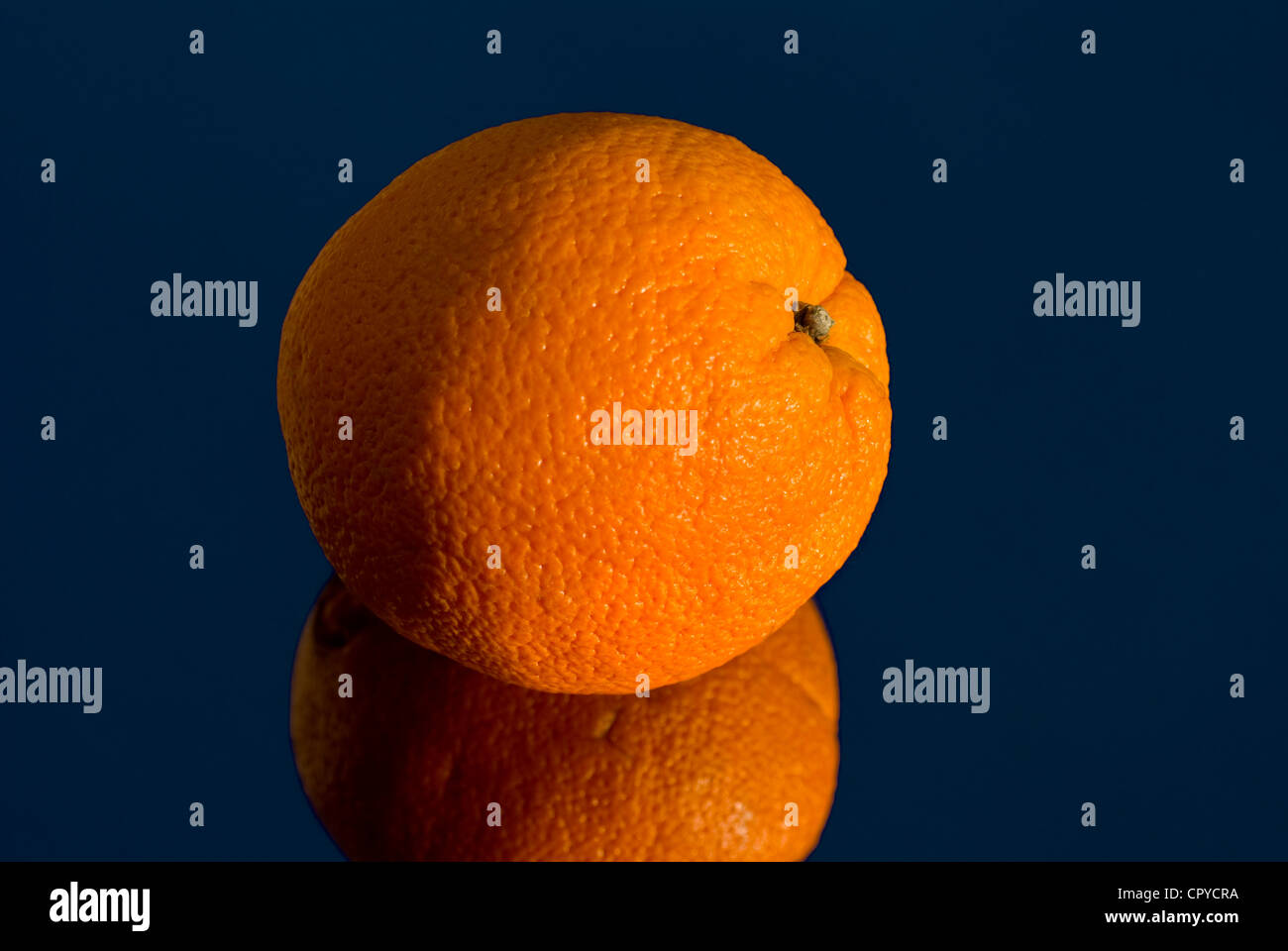 Orange in der Sonne auf einer reflektierenden Oberfläche Stockfoto