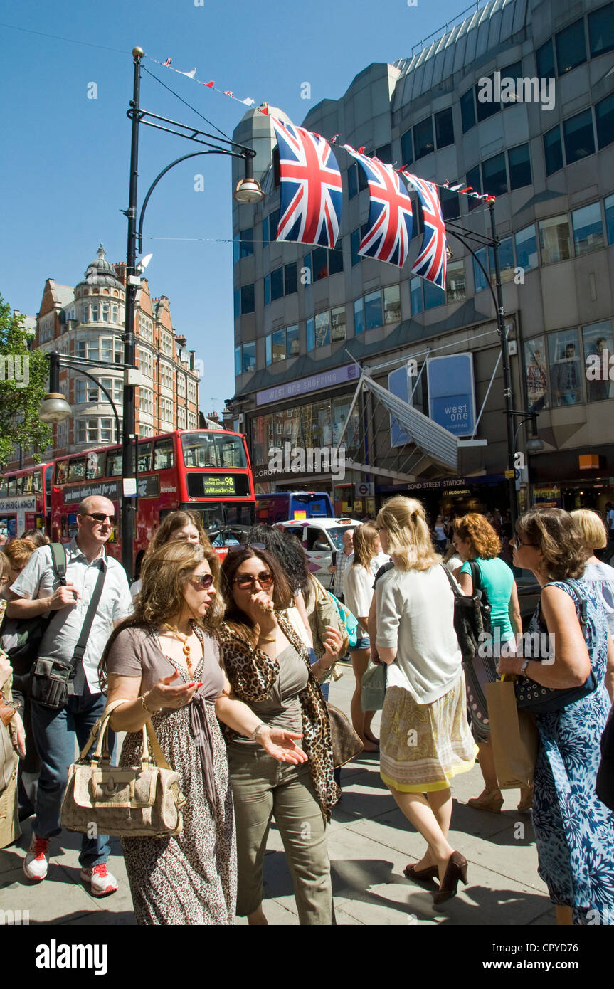 Massen von Menschen in der Oxford Street mit Fahnen, London England UK Stockfoto