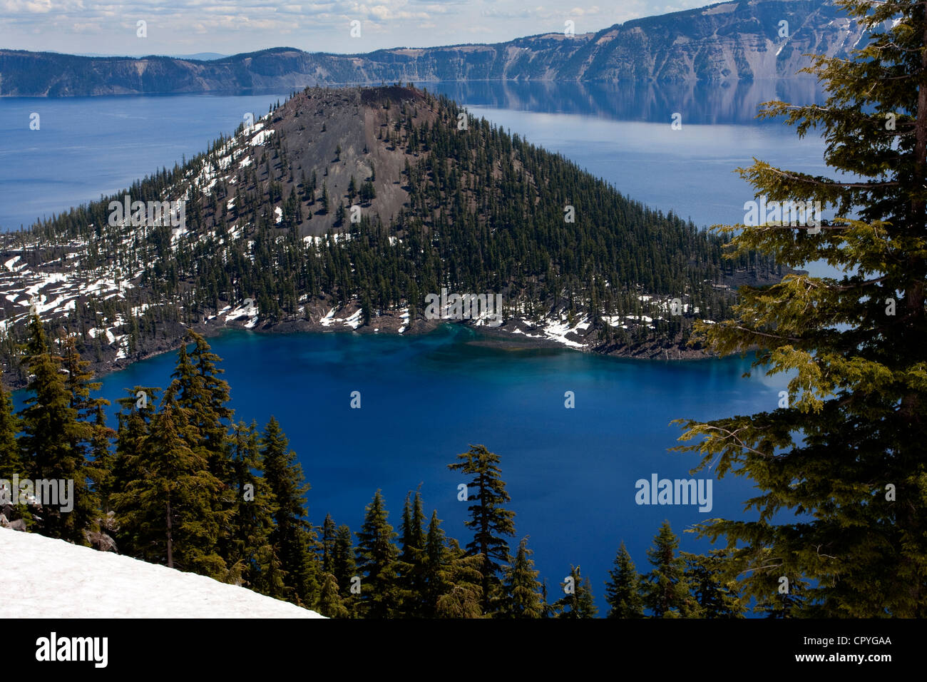 Einen malerischen Blick auf den Kratersee, Oregon, USA mit Wizard Island und Cloud Reflexionen auf dem See. Aufgenommen im Juni. Stockfoto