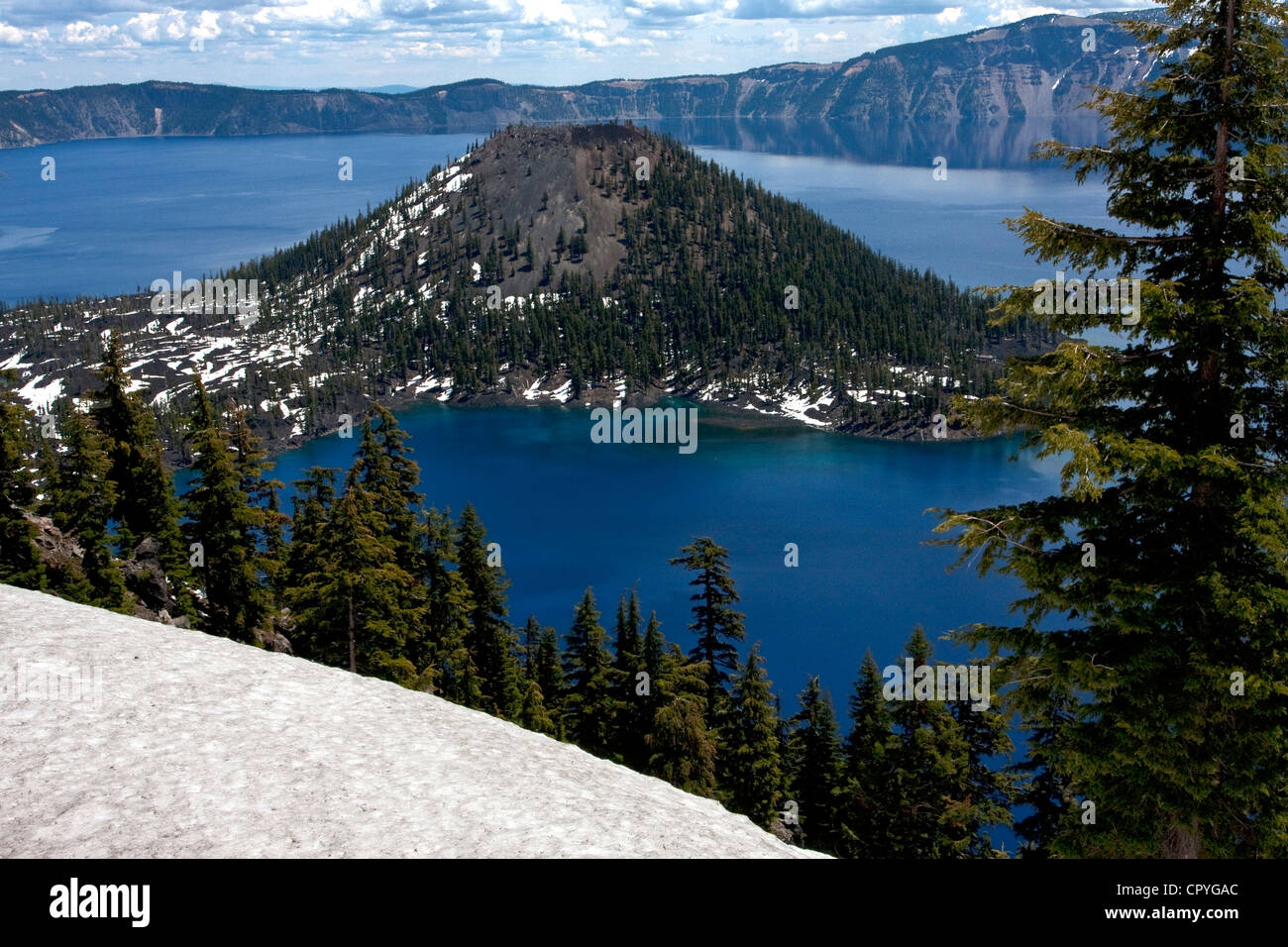 Einen malerischen Blick auf den Kratersee, Oregon, USA mit Wizard Island und Cloud Reflexionen auf dem See. Aufgenommen im Juni. Stockfoto