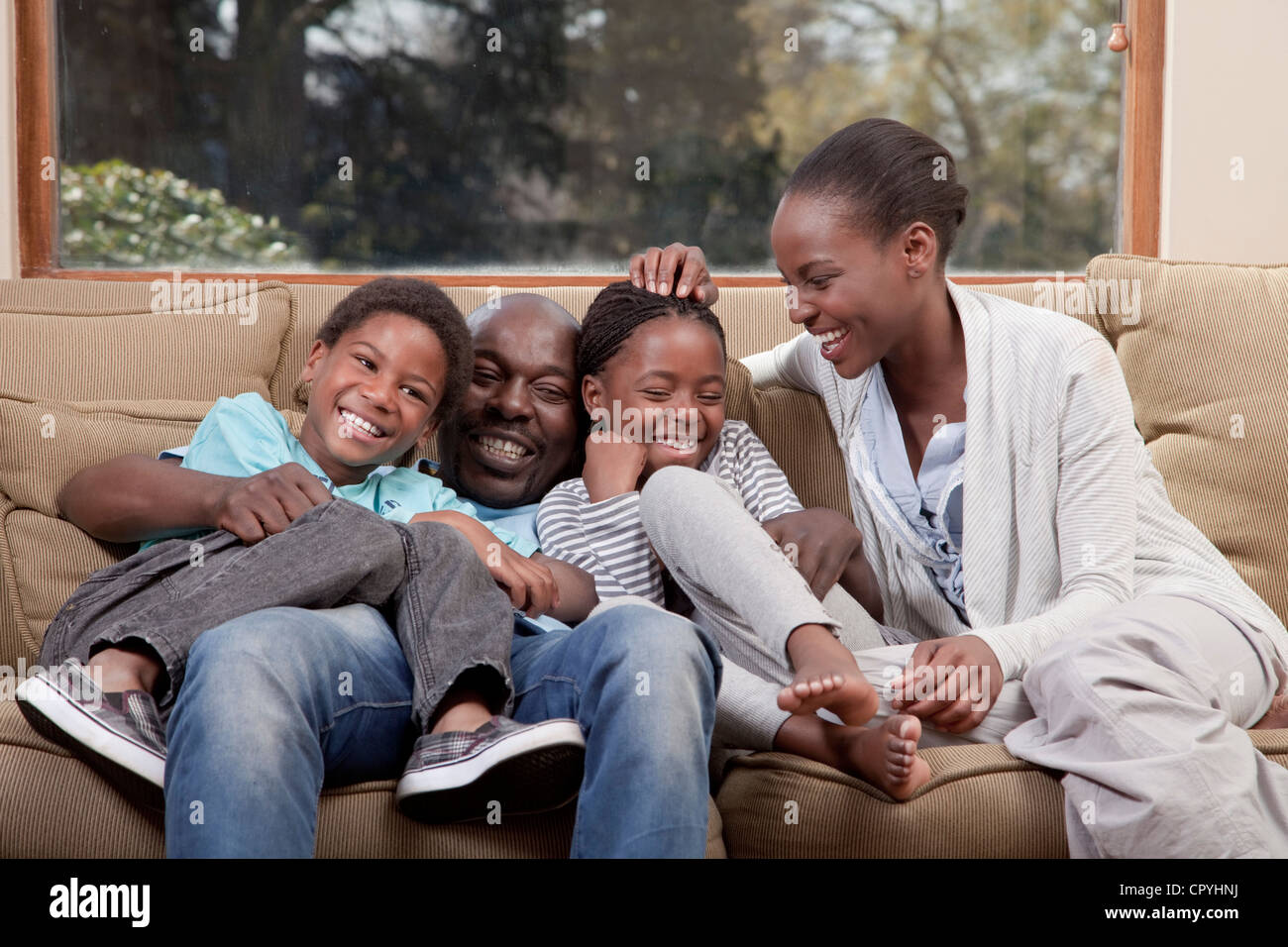 Familie, lachen und sitzen zusammen auf der Couch, Illovo Familie, Johannesburg, Südafrika. Stockfoto