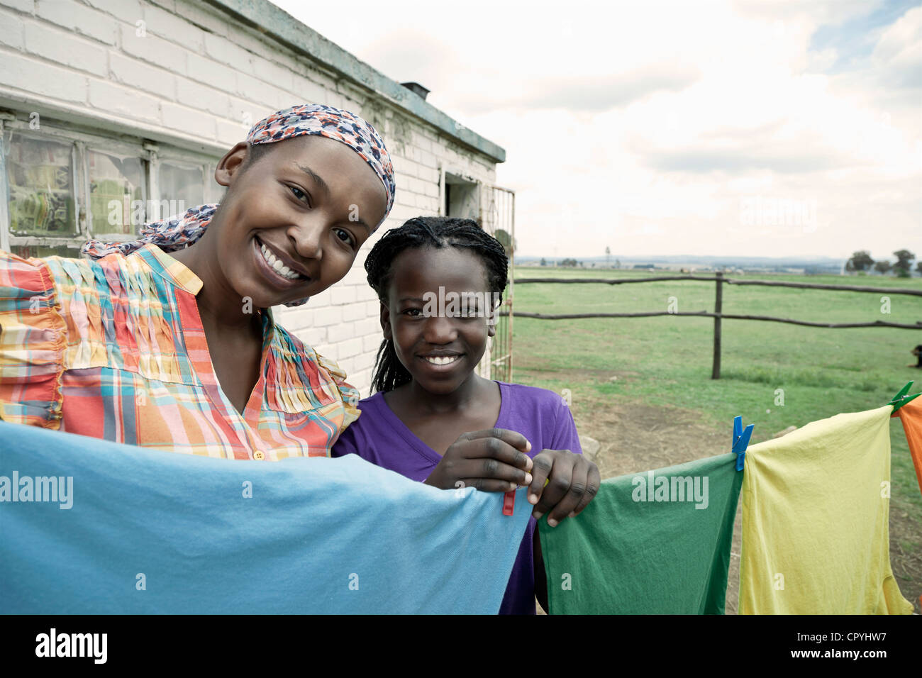 Schwarze Hündin hängt vor ihrem ländlichen Haus mit ihrer Tochter waschen Stockfoto
