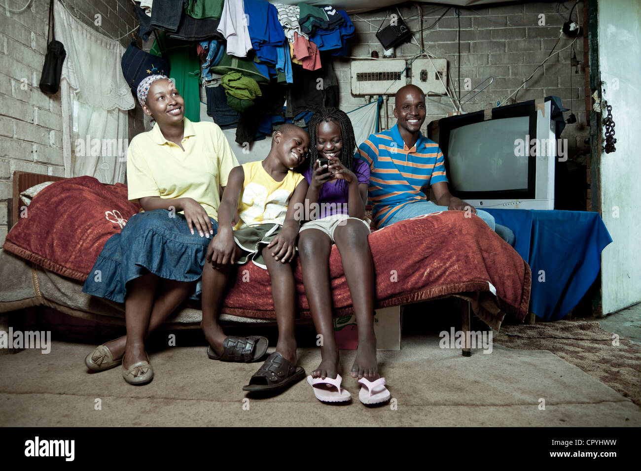 Afrikanische Familie sitzt zusammen auf einem Bett im Haus Stockfoto