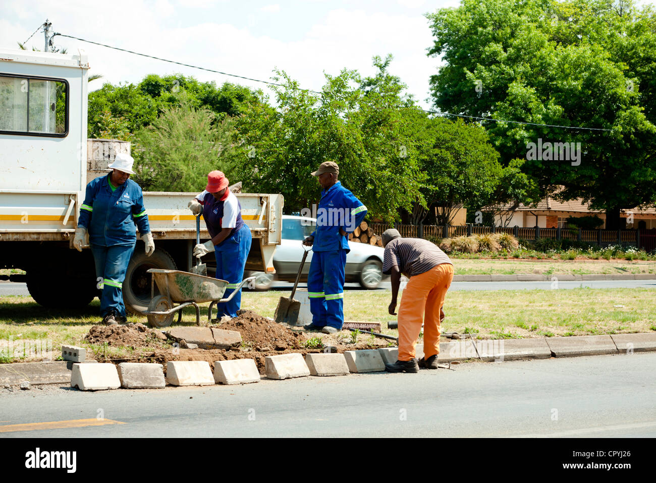 Vier afrikanische Gemeinde Arbeiter arbeiten an einem Straßenrand Stockfoto