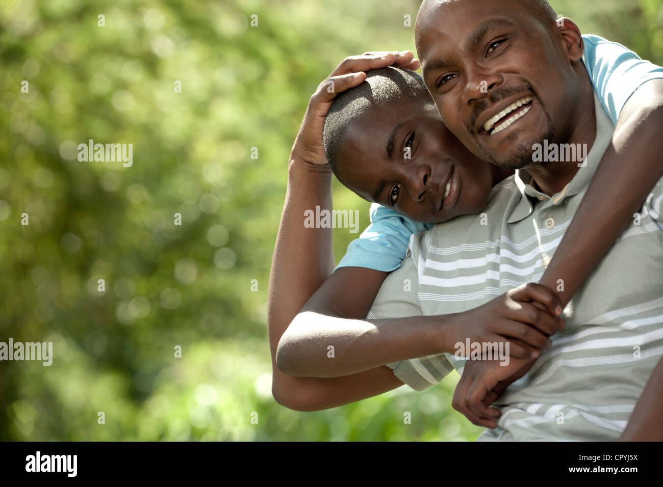 Afrikanischen Vater und Sohn sitzen draußen in einem Garten Stockfoto