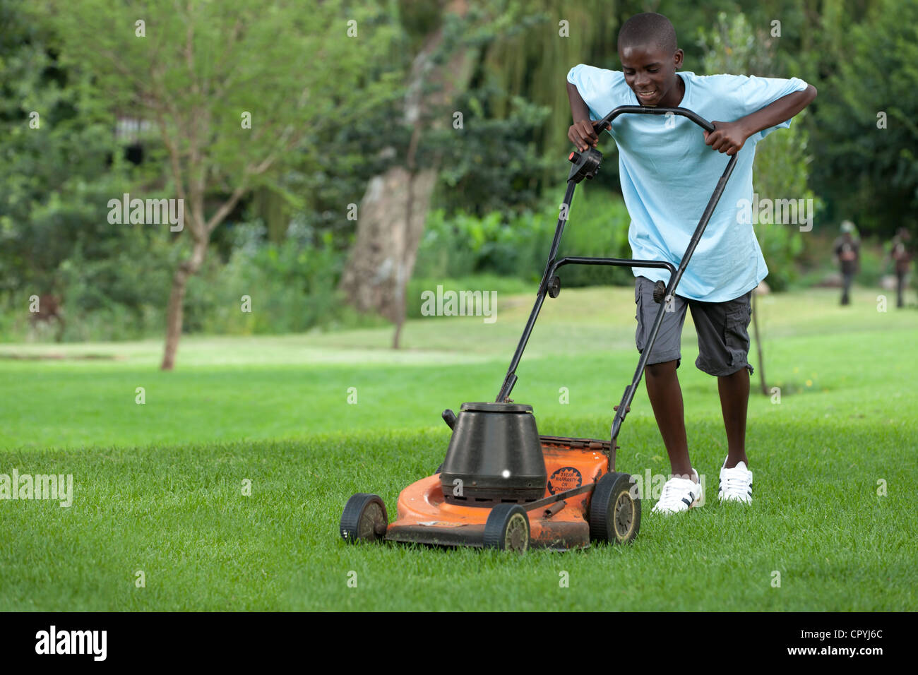 Afrikanischen jungen Rasen mähen Stockfoto