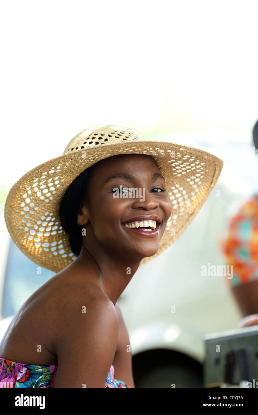 Porträt einer jungen schwarzen Frau trägt einen Hut und lächelt in die Kamera Stockfoto
