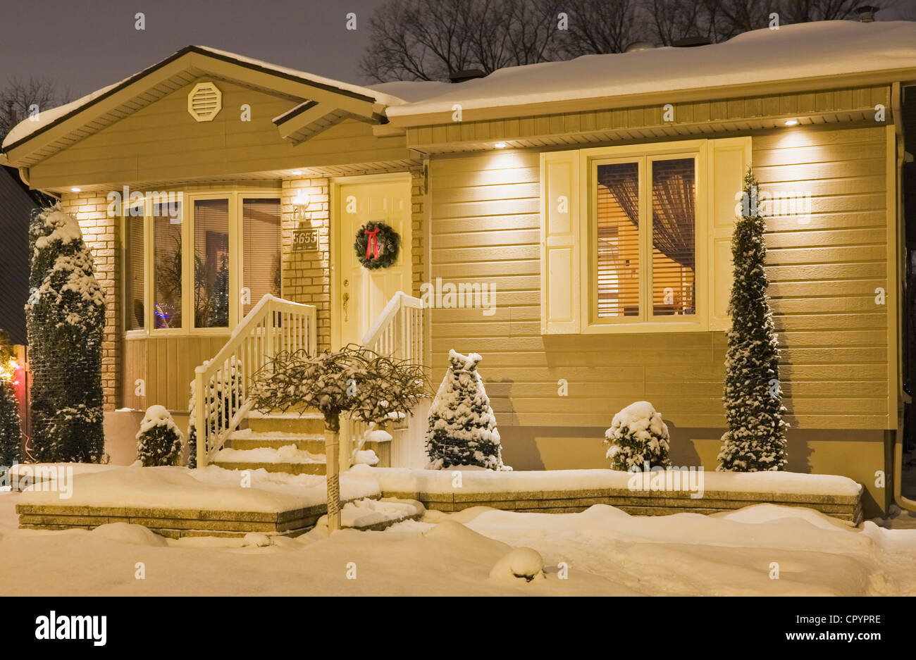Bungalow-Stil Heim beleuchtet im Winter in der Abenddämmerung mit Weihnachtsschmuck, Quebec, Kanada Stockfoto