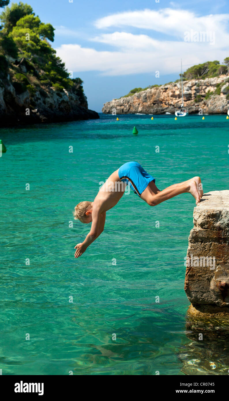Ein Junge springt ins Meer frontal, Cala Pi, südliche Küste von Mallorca Insel, Balearen, Spanien, Europa Stockfoto