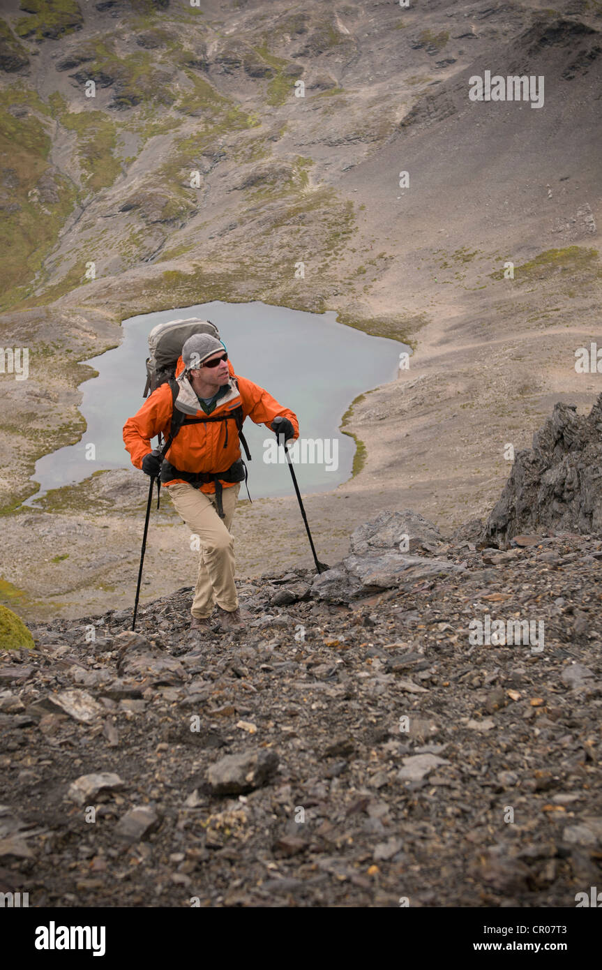 Wanderer gehen mit Stöcken in felsigen Hügeln Stockfoto