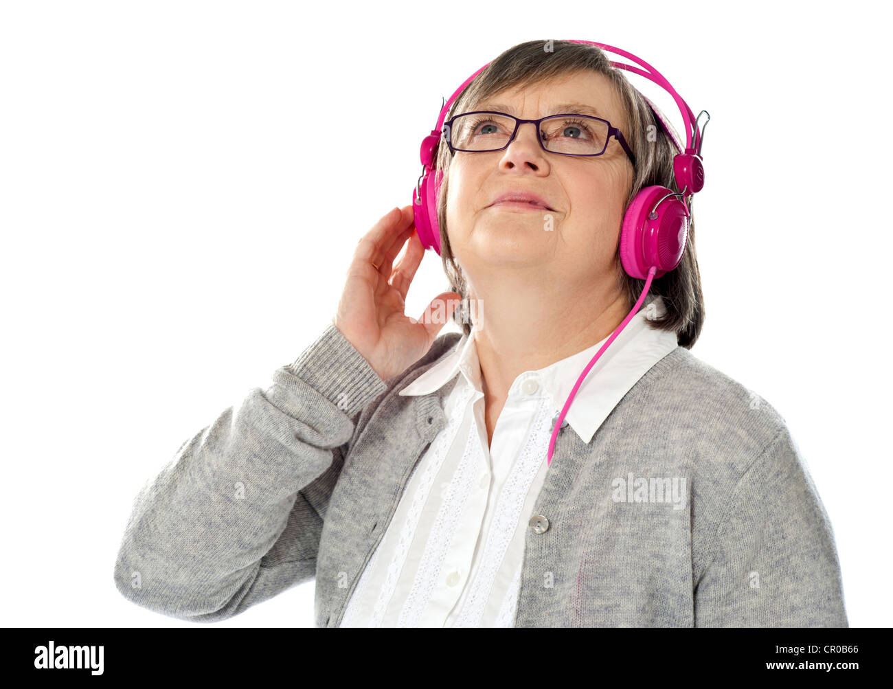 Alte Frau blickte, verlor in der Musikwelt. Isoliert Stockfoto