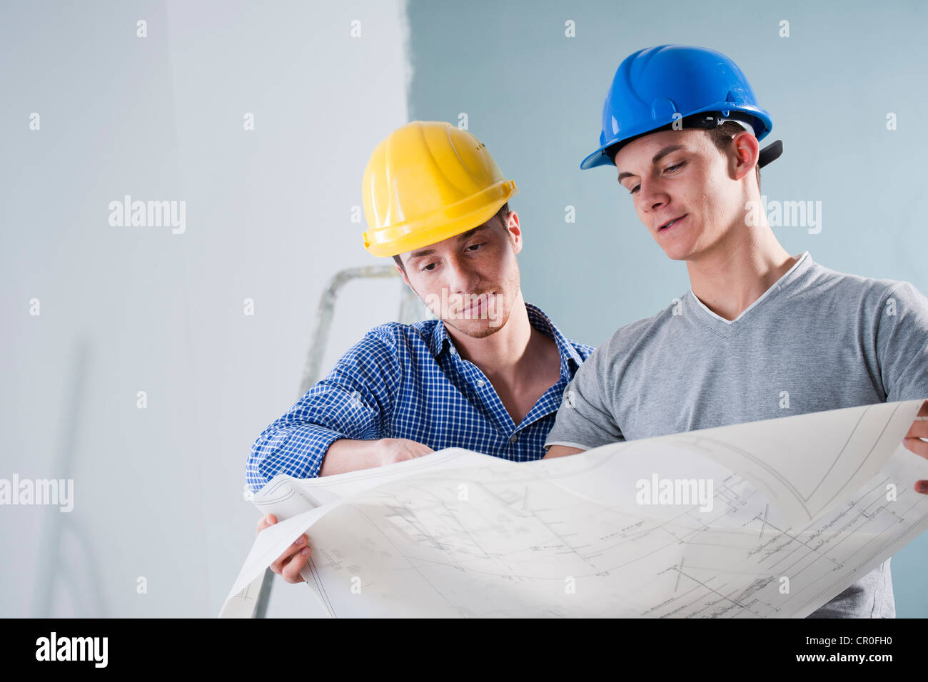 Zwei junge Handwerker betrachten einen Bauplan Stockfoto