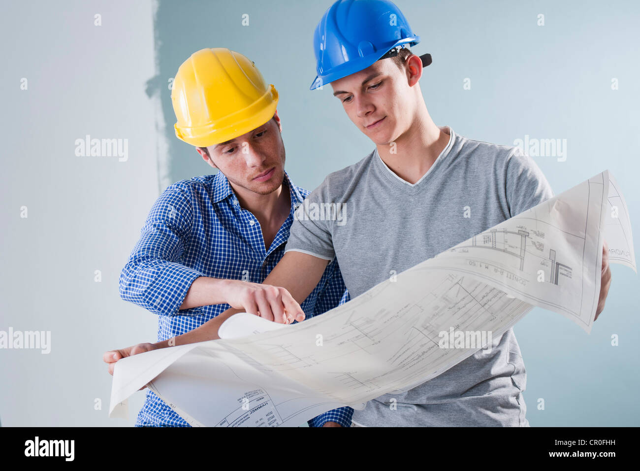 Zwei junge Handwerker betrachten einen Bauplan Stockfoto