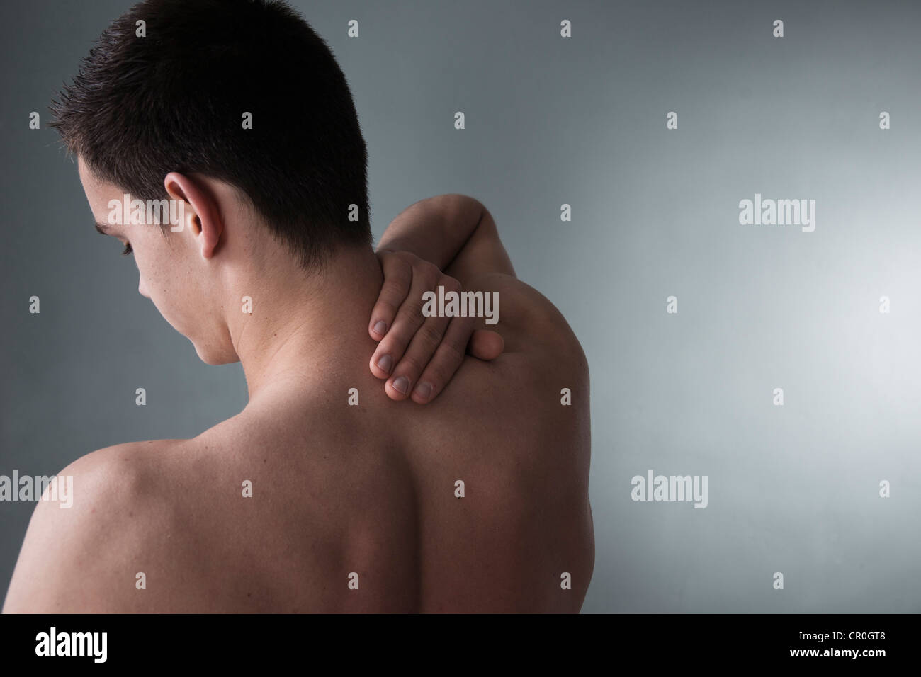 Junger Mann mit Rückenschmerzen, Nackenschmerzen Stockfoto