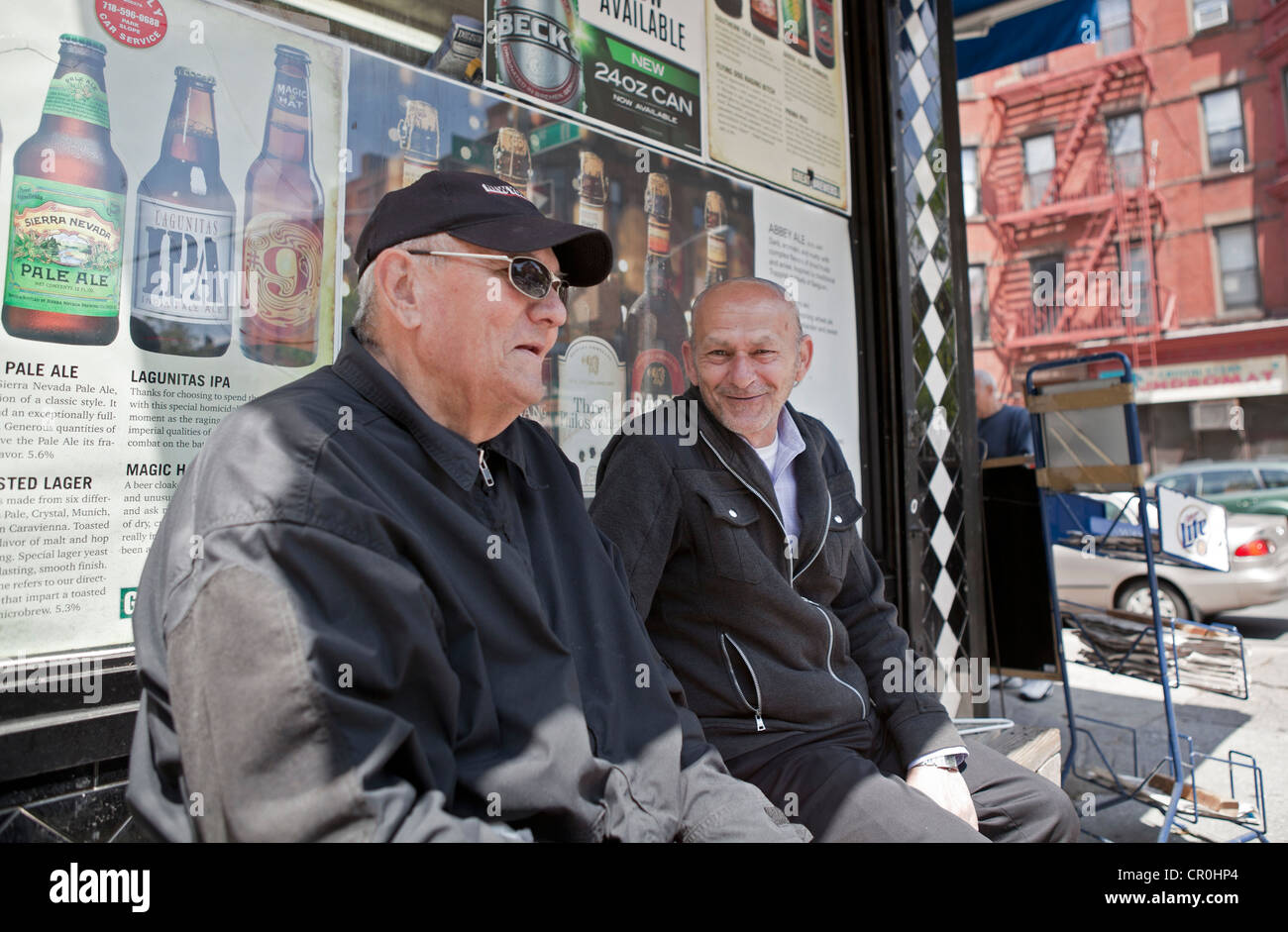 2 alte Freunde erinnern sich vor einem Tante-Emma-Laden in Brooklyn, New York. Stockfoto