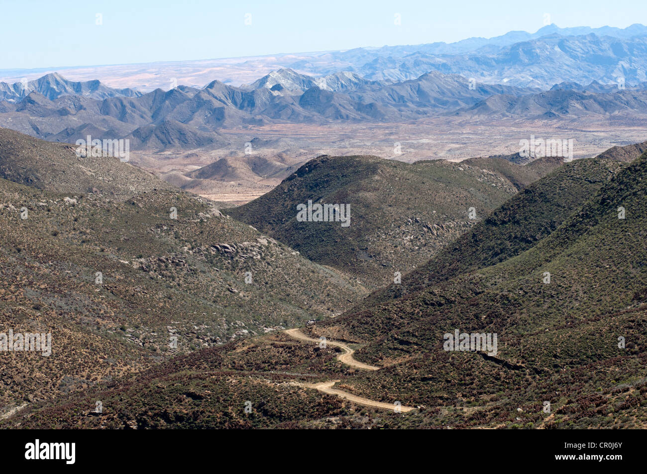 Trockenes Tal mit Straße in einer Karoo Landschaft am Helskloof-Pass, Richtersveld-Nationalpark, Namaqualand, Provinz Northern Cape Stockfoto