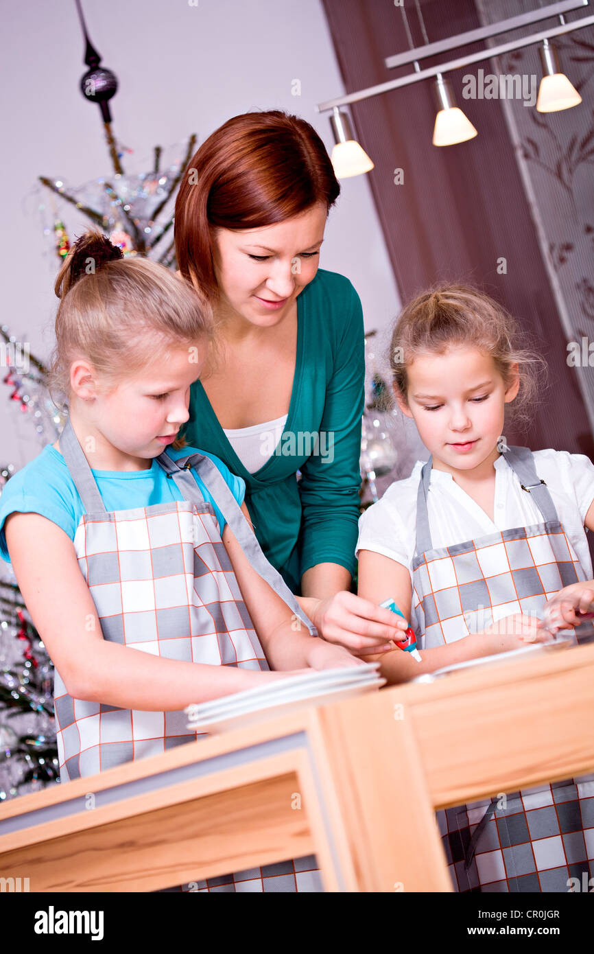 Zwei Mädchen, 11 und 8, Backen Weihnachtsplätzchen mit ihrer Mutter Stockfoto