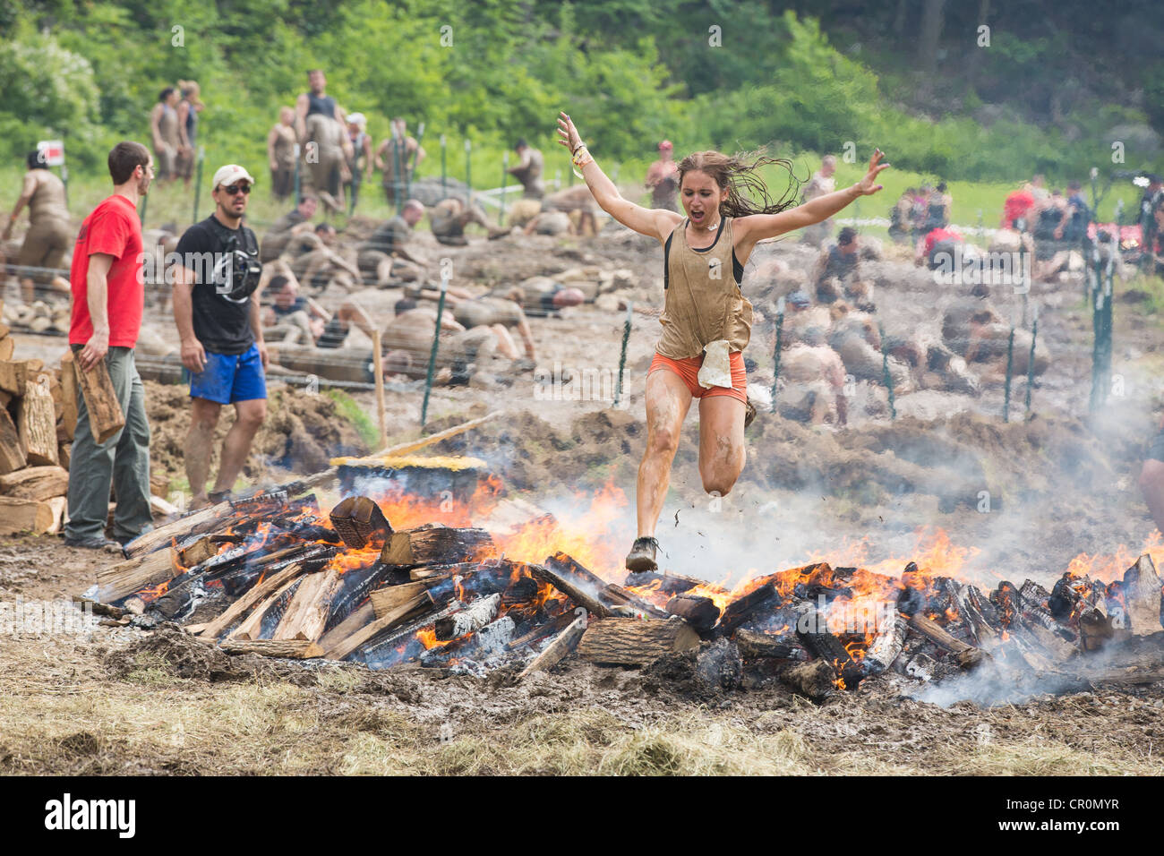 Junges Weibchen springen Feuer, letzte Hindernis eine herausfordernde Sprintrennen Trail, Spartan Race. Stockfoto Junges Weibchen springen Feuer, letzte Hindernis eine herausfordernde Sprintrennen Trail, Spartan Race. Stockfoto