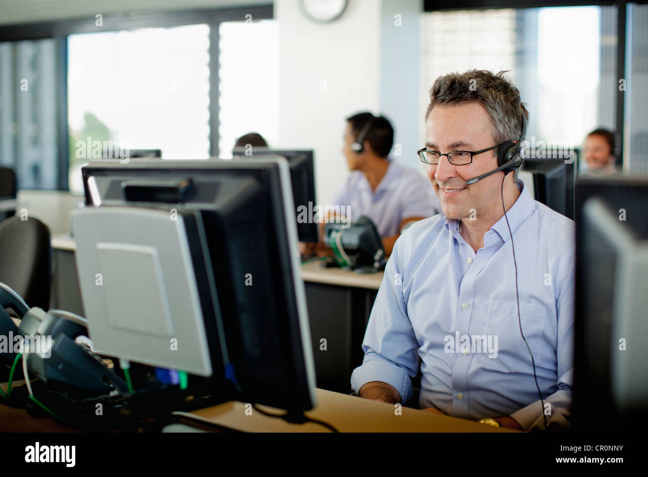 Geschäftsleute, die Arbeit am Computer im Call-center Stockfoto