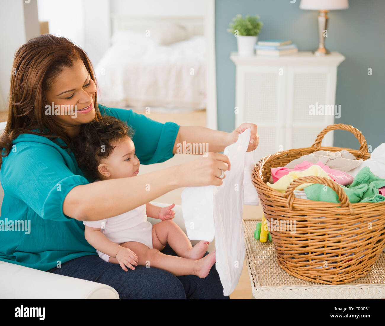Mischlinge Mutter Falten, Wäsche und halten baby Stockfoto