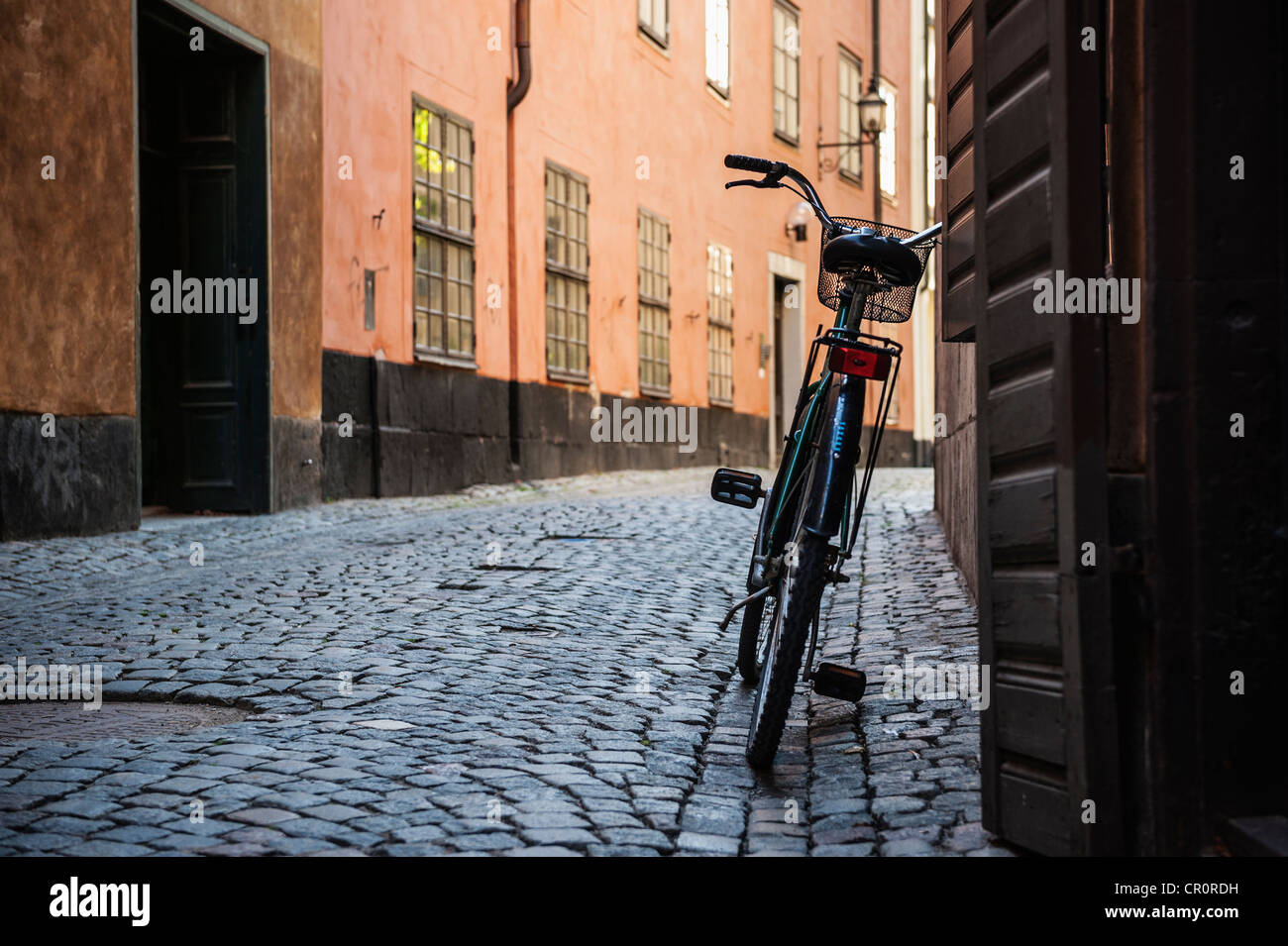 Fahrrad Wand gelehnt, auf engen Kopfsteinpflaster Straße, Gamla Stan, Stockholm, Schweden Stockfoto