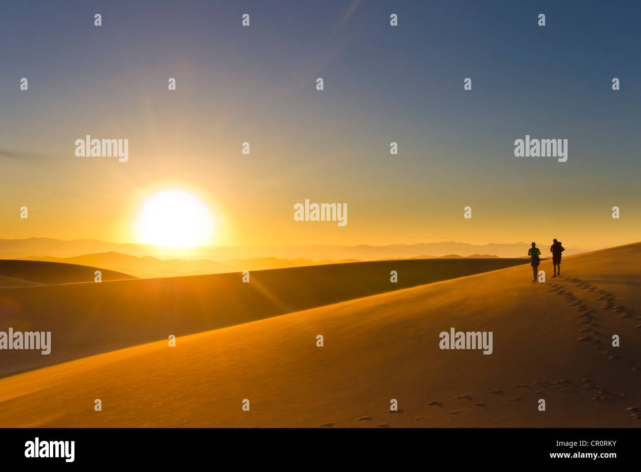 Hispanische paar zu Fuß auf Sand Dune bei Sonnenuntergang Stockfoto