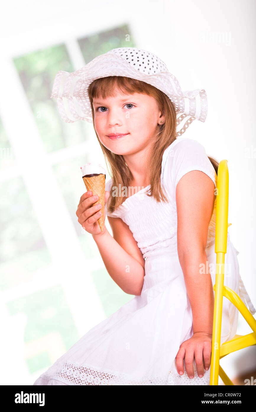 Junges Mädchen trägt ein weißes Kleid und Hut, ein Eis essen  Stockfotografie - Alamy