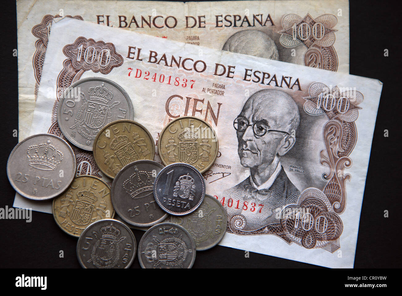 Spanische Peseta-Banknoten und-Münzen auf schwarzem Hintergrund Stockfoto