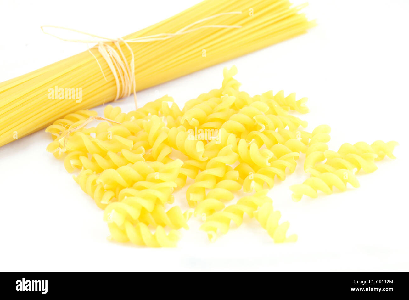 Nahaufnahme von Spaghetti und Fusilli auf weißem Hintergrund, Fokus auf fusilli Stockfoto
