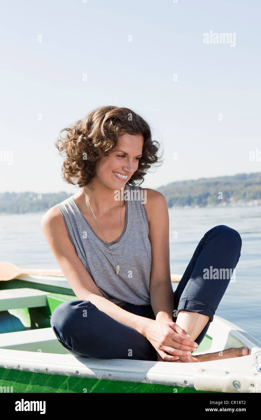 Frau sitzt im Boot noch See Stockfoto