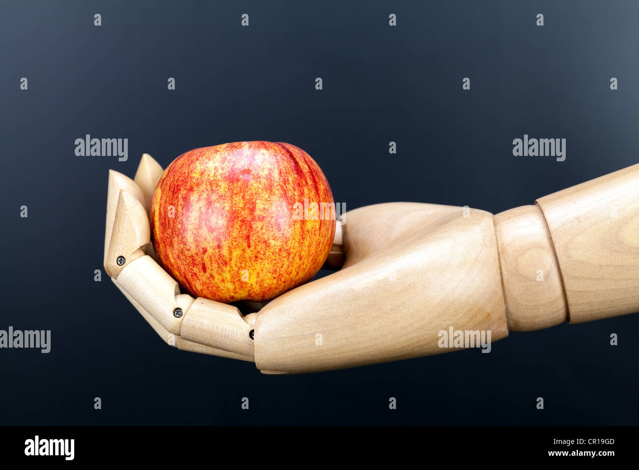 Stillleben Apfel in hölzernen Hand vor einem dunklen Hintergrund Stockfoto