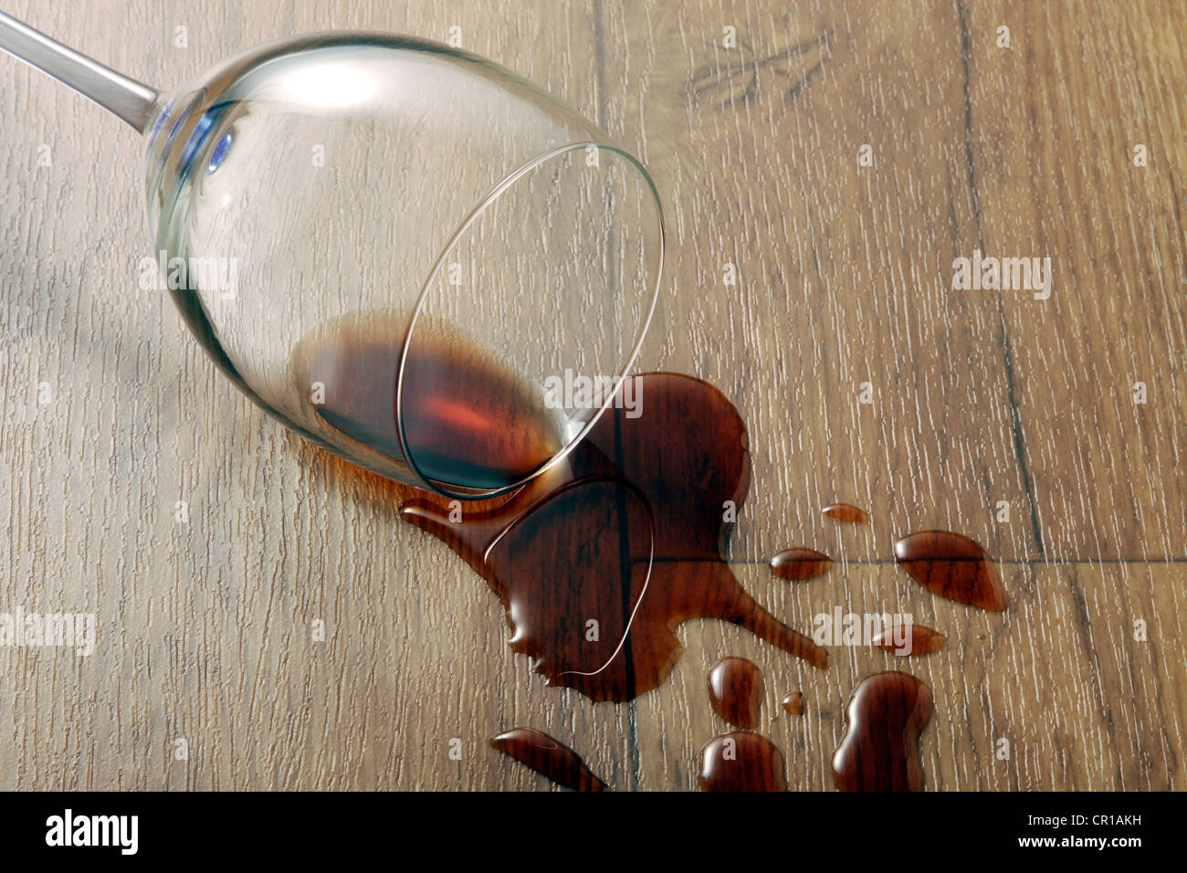 Glas Wein und verschüttete Rotwein auf eine langlebige Vinyl-Böden mit Holzoptik Stockfoto