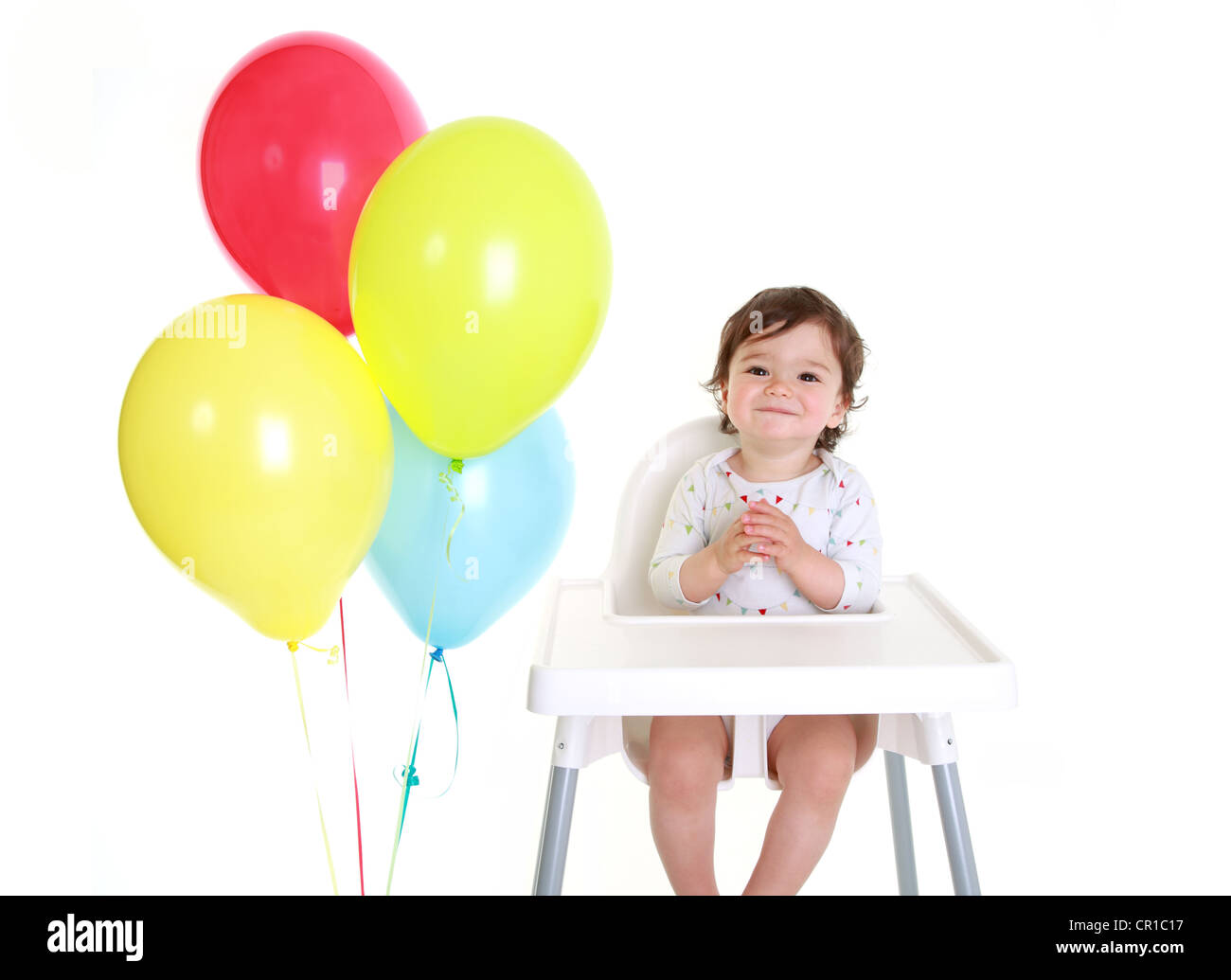 Baby im Hochstuhl mit Luftballons Stockfoto