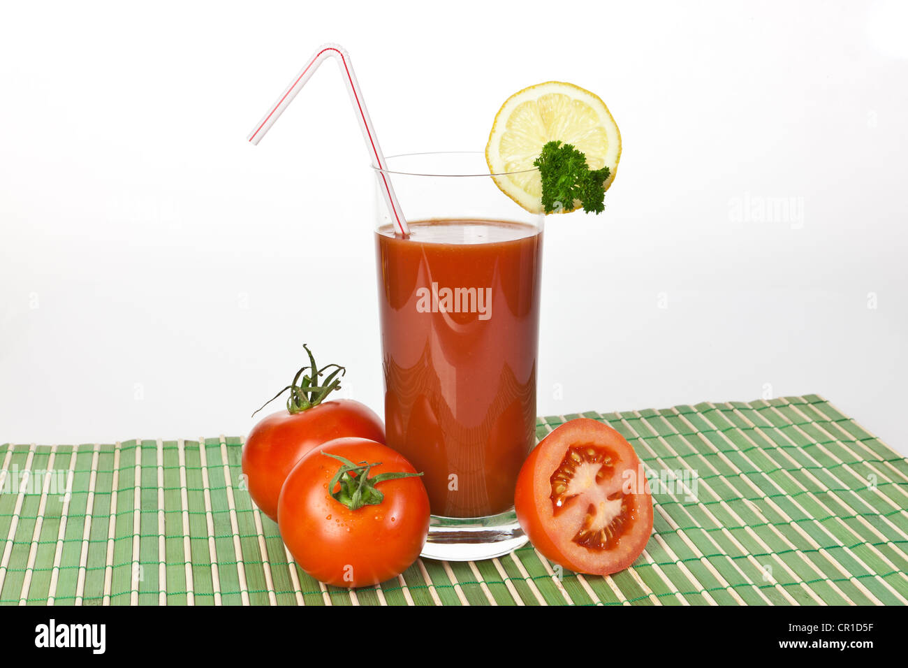 Tomatensaft in einem Glas mit Tomaten und Zitrone Stockfoto