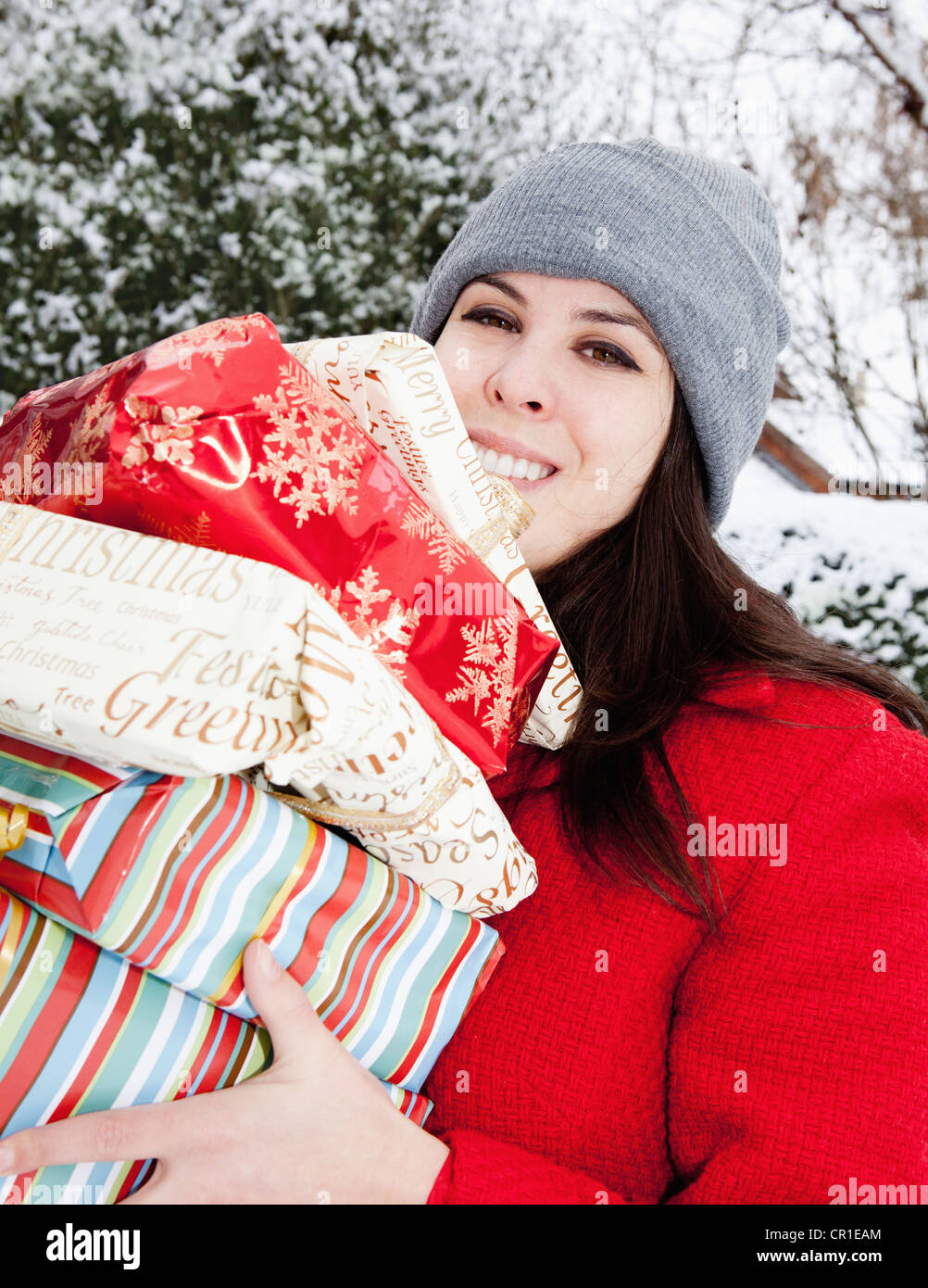 Frau, die Geschenke in Schnee gehüllt Stockfoto