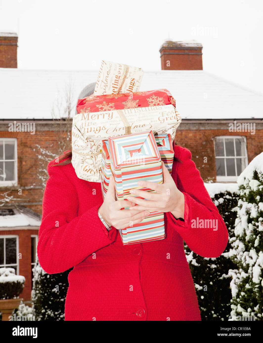 Frau, die Geschenke in Schnee gehüllt Stockfoto