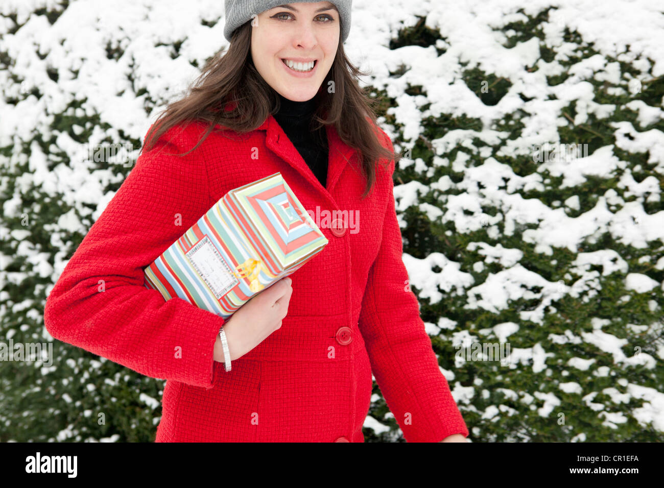 Frau mit Geschenk in Schnee gehüllt Stockfoto