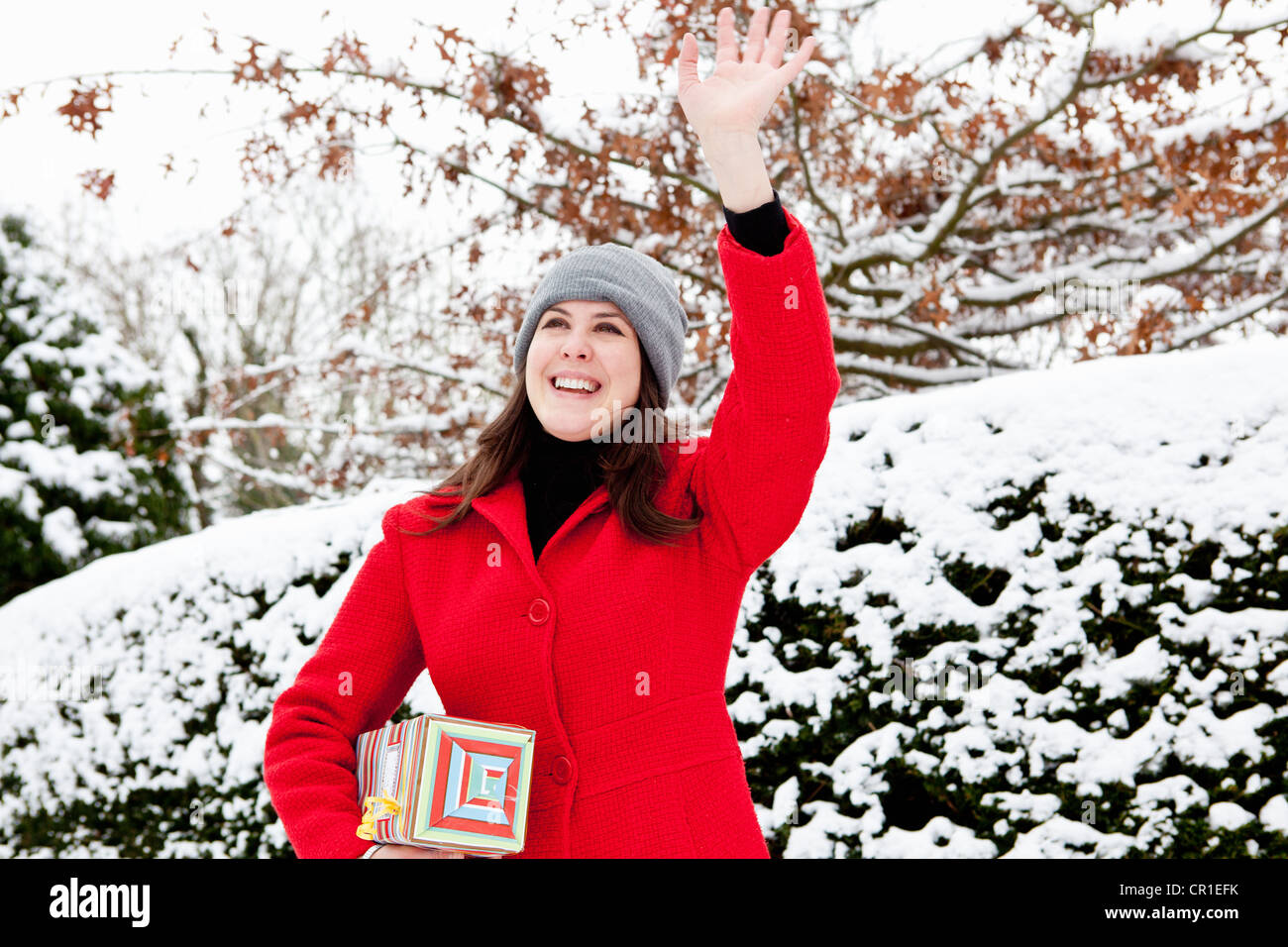 Frau mit Geschenk in Schnee gehüllt Stockfoto