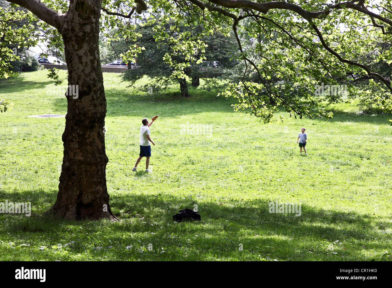 Quintessenz amerikanischen Sommer-Szene wie Papa spielt fangen mit kleinen Sohn auf einer sonnigen Wiese Riverside Park in New York City Stockfoto