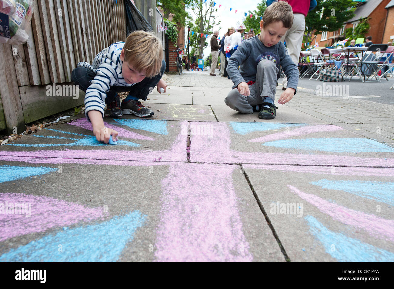 Kuchen, Wimpel, Gesicht malen und Champagner sind im ein Straßenfest in South West London trotz der ungeraden Platzen der Regen. Stockfoto