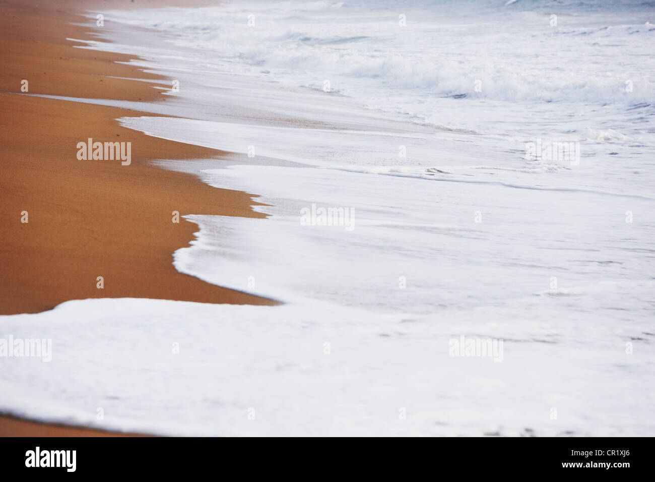 Wellen am Sandstrand Stockfoto