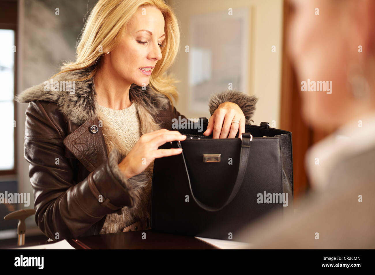 Frau beim Stöbern durch Geldbörse Stockfoto