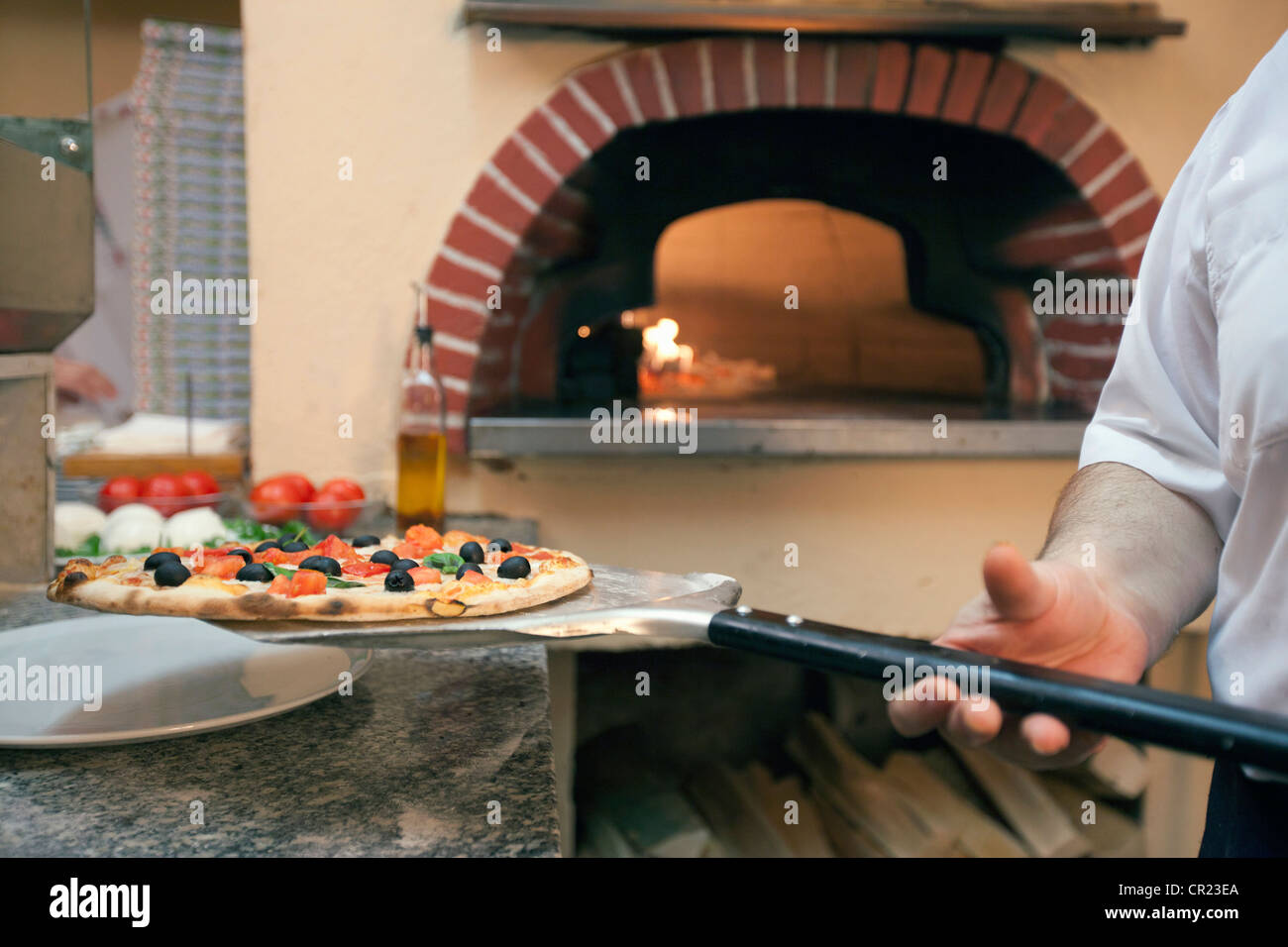 Koch Holding Pizza auf Spachtel Stockfoto