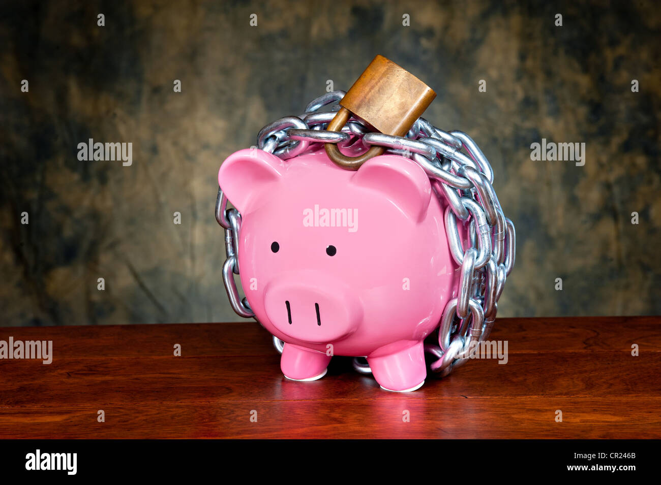 Ein rosa Sparschwein angekettet und gesperrt. Bild kann für finanzielle Absicherung Rückschlüsse oder andere Investition-Nachrichten verwendet werden. Stockfoto