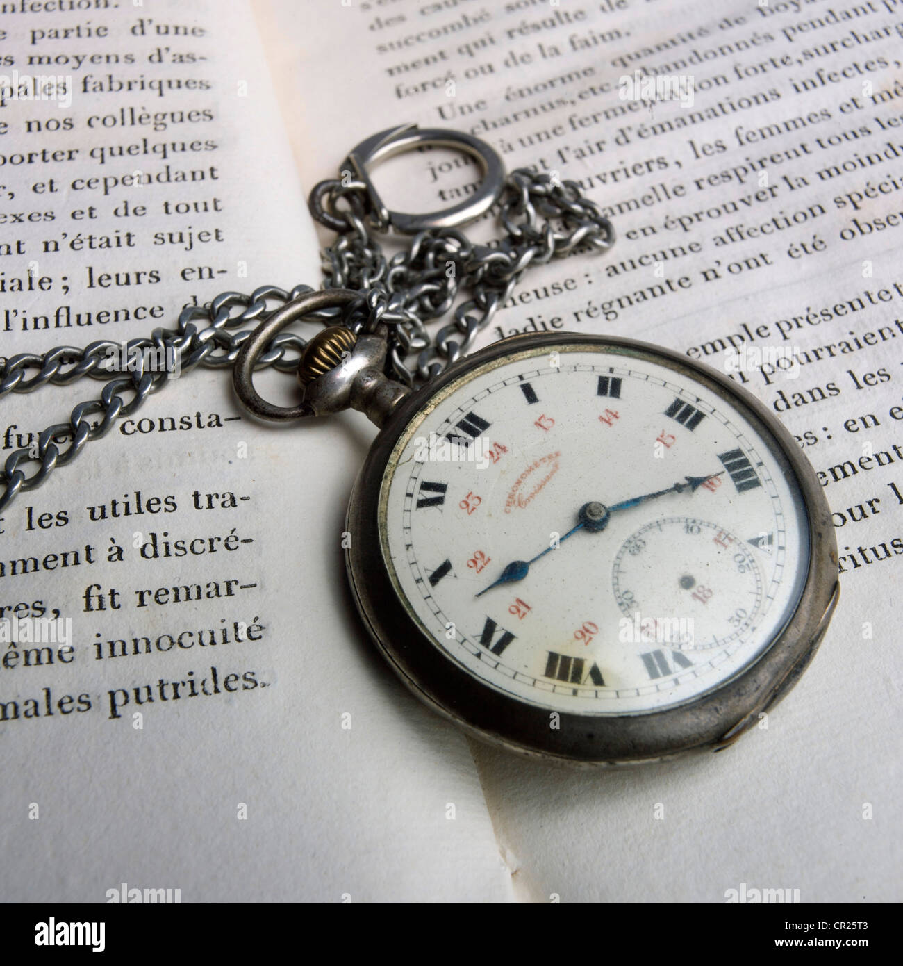 Taschenuhr und offenen französischen Buches. Stockfoto