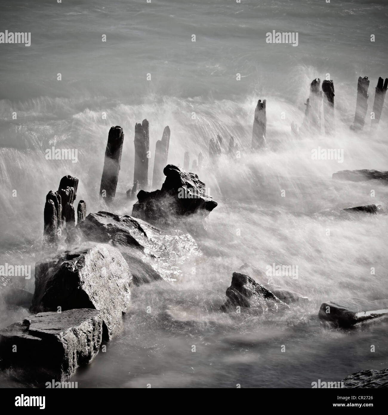 Wellen brechen über hölzerne Pfähle Stockfoto