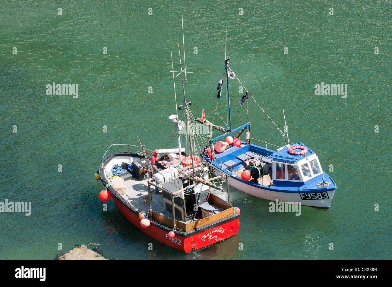 Angeln und Boote vertäut warten auf Passagiere am Polperro, Cornwall, UK Stockfoto