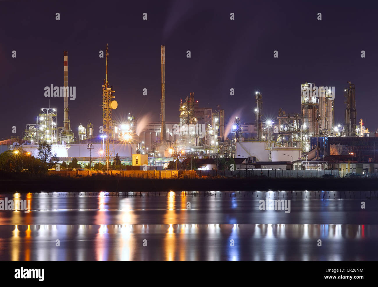 Nachtaufnahme von petrochemischen Anlage mit Wasserreflexion Stockfoto